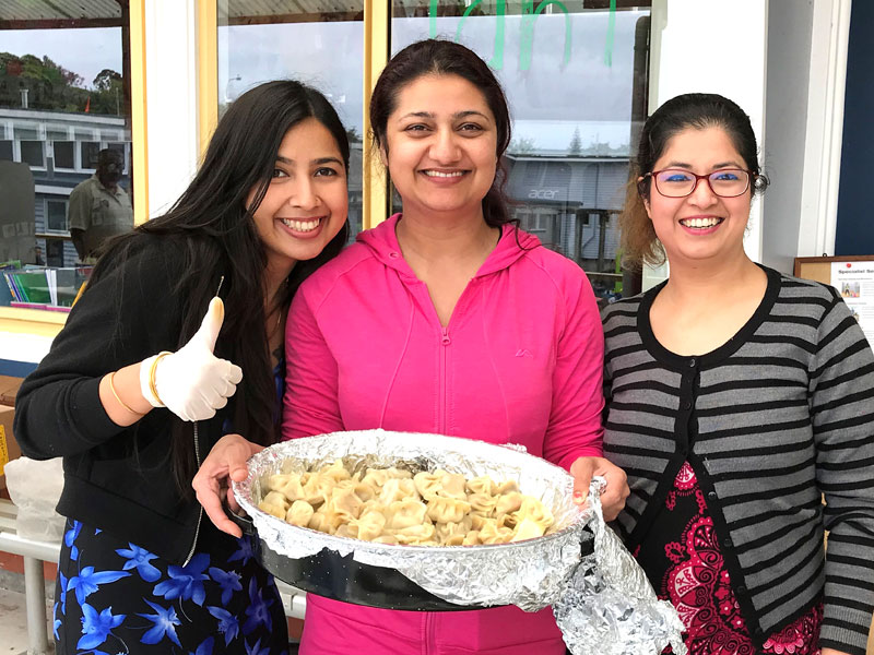 Diksha Niraula serving up the Nepalese dumplings she prepared with the help of franchisees Vrinda Nautiyal (left) and Isha Pyakurel. 