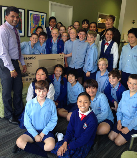 The kids from Sunnyhills Primary School with their new TV, presented by CrestClean’s East Auckland Regional Director Viky Narayan.