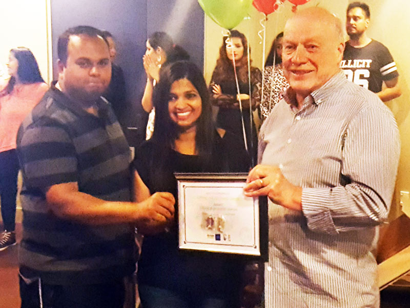 Dhiraj and Grijeshni Sharan receive their five-year Long Service Award from Richard Brodie.