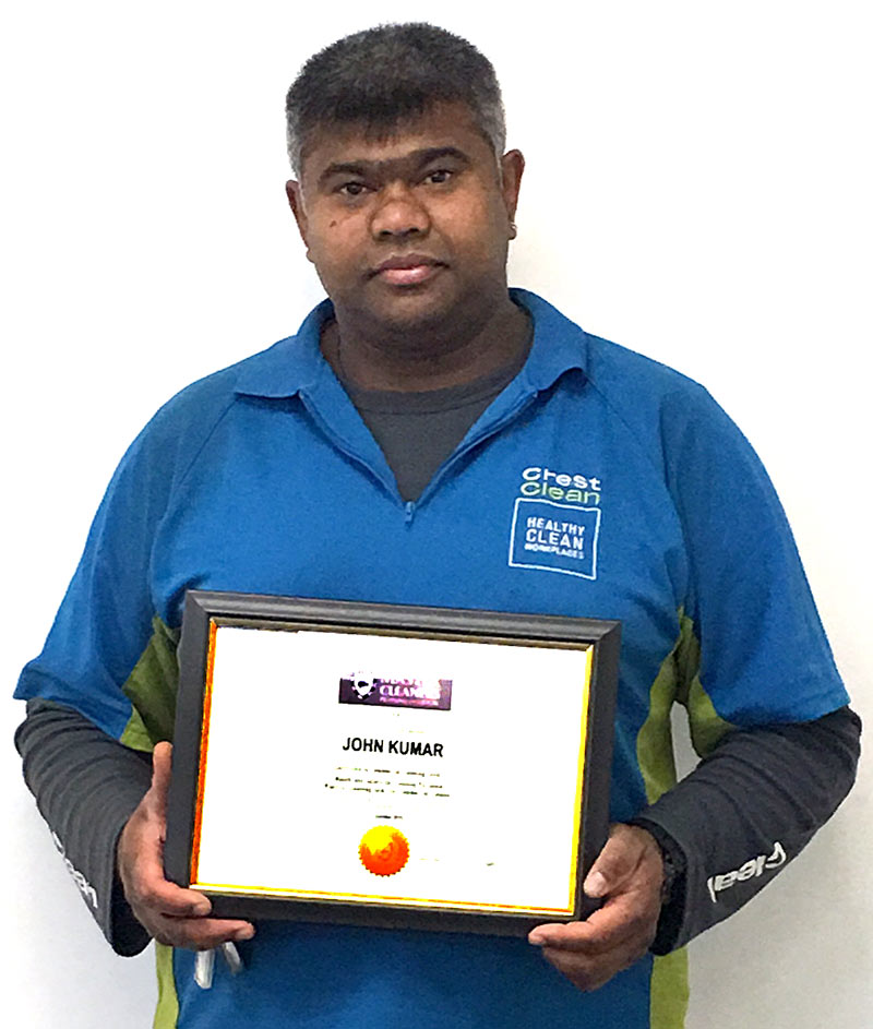 John Kumar proudly holds his award.