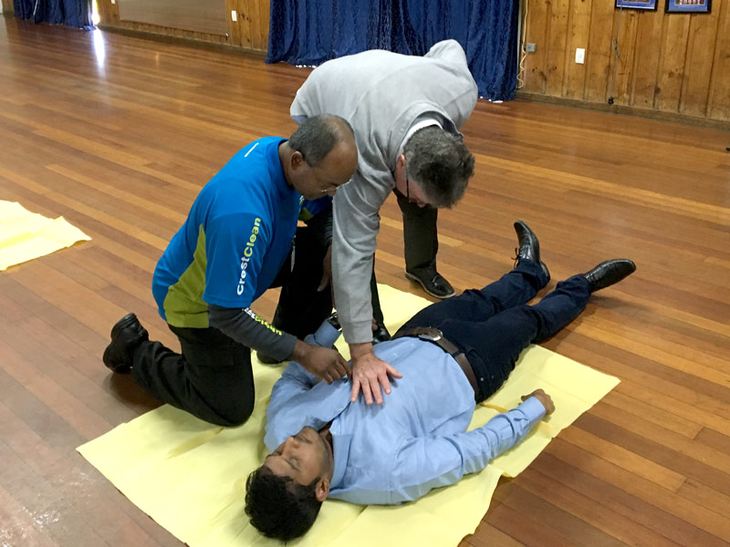 Master Cleaners Training Institute CEO Adam Hodge oversees the course as participants try CPR techniques.