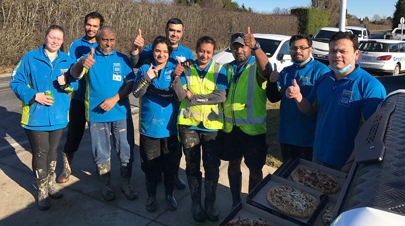 Well-earned pizza for CrestClean teams at Mosgiel pictured taking  a break from the flood clean-up work.