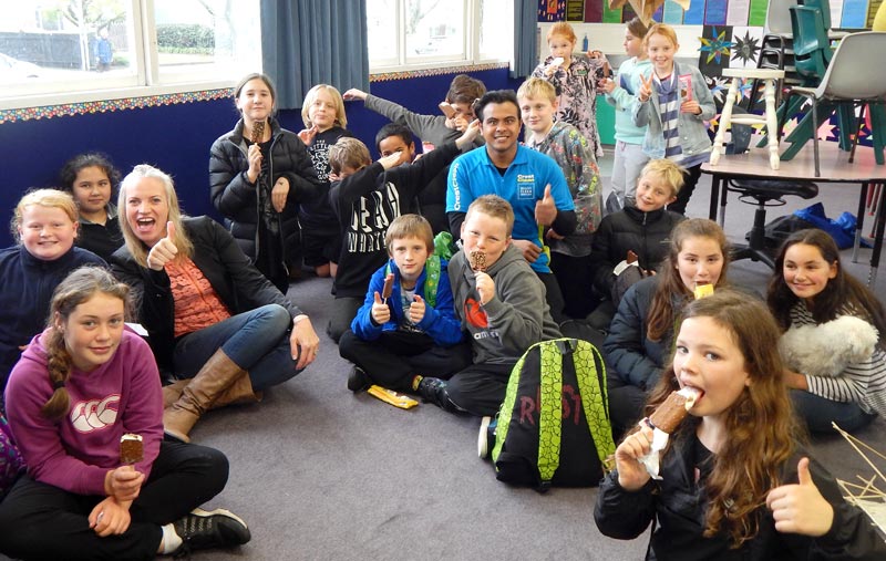 Izack Ahmed and Abby Latu give out ice-creams to students at Nelson Park Primary School after presenting the Cleanest Classroom Award to Room 17 pupils.