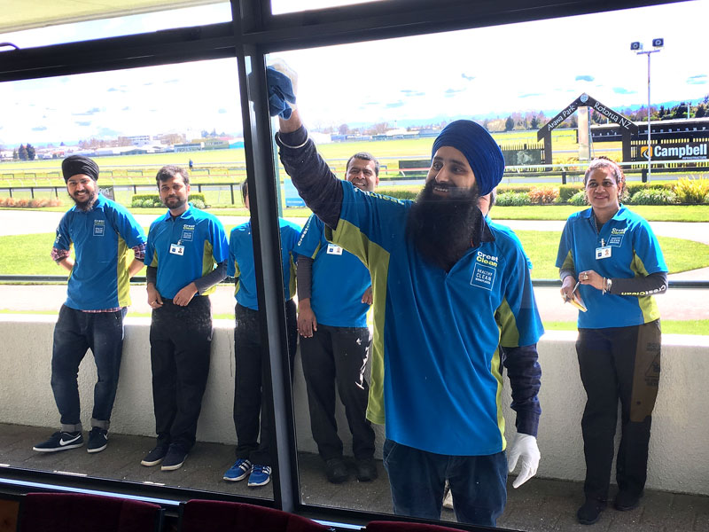 Sandeep Singh tries his hand on a large window at Rotorua Race Course during a Master Cleaners Training Institute training session.