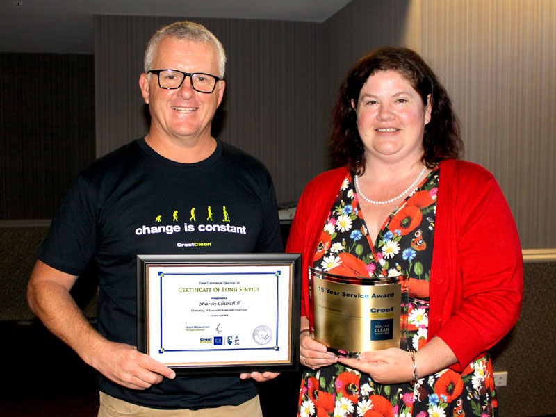 Sharon Churchill receives her long service award from Grant McLauchlan.