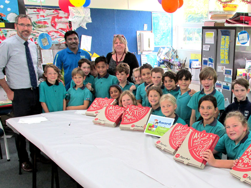 CrestClean’s Jay Gounder presents pizza to children at Hastings Christian School after they won the Cleanest Classroom Award.