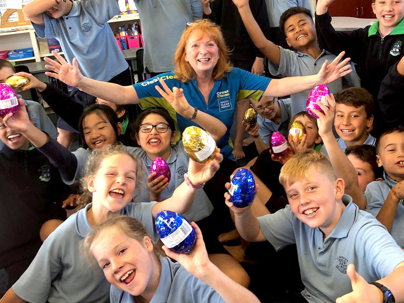 Deborah Herries hands out Easter eggs to children who won the Cleanest Classroom competition at St Patrick’s School, Napier.