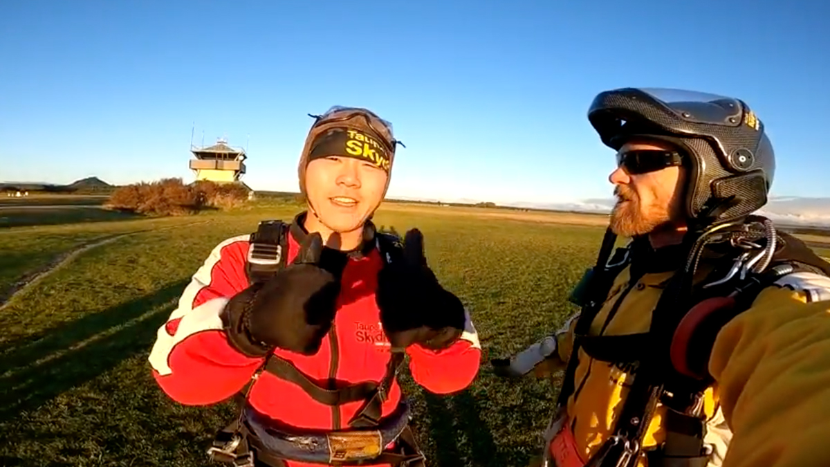 Man giving thumbs up after skydive.