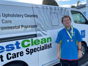 Cleaner wearing sports medals around his neck.